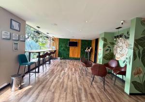 a room with a table and chairs and a bar at Greenview Medellin By St Hoteles in Medellín