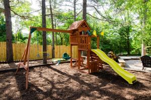a playground with a slide and a swing set at Whispering Woods Cabins & Grill in Jordan