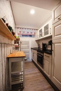 a kitchen with white cabinets and a wooden floor at Ferienwohnung Rose in Walkenried +22 photos