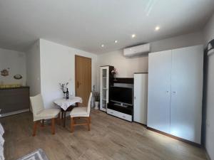 a living room with a table and chairs and a television at Studio Ivanka in Jurandvor