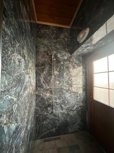 a bathroom with a shower in a stone wall at Bahçeli Taş Villa in Trabzon +28 photos
