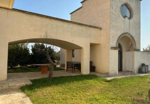 a building with an archway in front of a table at Masseria Le Celline in Nardò