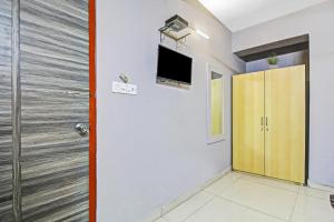 ĀlīpurHotel O The Jumbo Stay的一间设有门的房间和墙上的电视