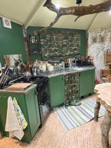 a kitchen with green cabinets and a stove at The Oak Tree House in Westport