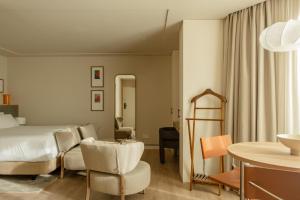 リスボンにあるPOSTCODE Liberdadeのベッドとテーブルのあるホテルの部屋