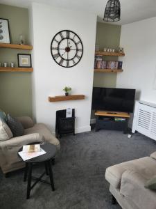 ラグビーにあるRugby town centre house close to rugby train station and rugby schoolのリビングルーム(壁に大きな時計付)