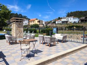a patio with chairs and a table and a table and chairs at Hotel Apartamento Marouco in A Guarda