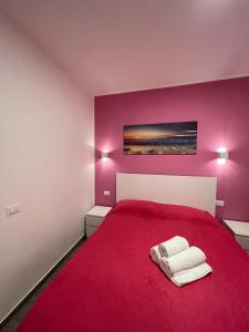 a bedroom with a red bed with two towels on it at Casa Macallè - Letojanni - Taormina in Letojanni +127 photos