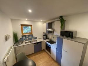 a small kitchen with a refrigerator and a microwave at Gemütliche Wohnung ruhig gelegen 75qm in Ehingen +5 photos