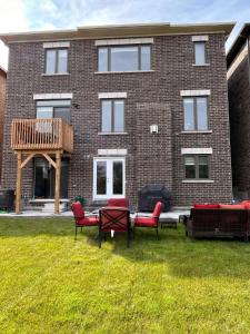a brick building with chairs and a table in the yard at Whitby Hideout - 3BR, 5BD, 3WR, Pool Table, Sauna in Whitby