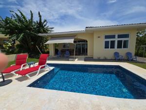 a villa with a swimming pool and a house at Casa Tanamera in Boca Chica
