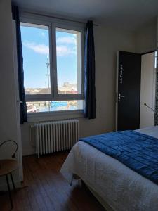 a bedroom with a bed and a large window at Voiles et Terrasses by Corinne Résidence face au port in Le Tréport