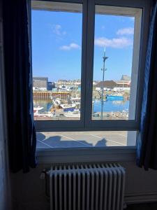 a window with a view of a marina at Voiles et Terrasses by Corinne Résidence face au port in Le Tréport
