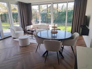 a living room with a table and chairs at Spring Villa Ioor in Ermelo