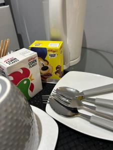 a plate with a spoon and fork and a box of cereal at Deluxe Studio Coventry in Parkside