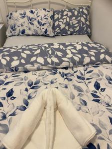 a bed with blue and white sheets and pillows at Deluxe Studio Coventry in Parkside
