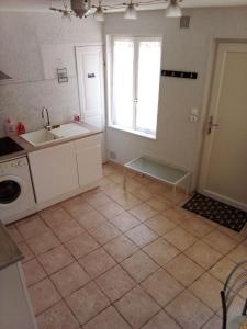 eine leere Küche mit Spüle und Fenster in der Unterkunft Maison de ville in Marzy