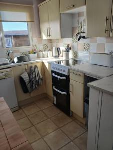 a kitchen with a sink and a stove top oven at Shed No 9 in Colyford