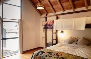 a bedroom with a bed and a large window at Villas del Valle Sagrado in Cusco