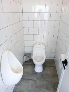 a bathroom with a toilet and a urinal and a sink at casa oasis in Tecomán