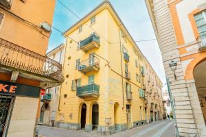 a yellow building on the side of a street at Petite Maison Cuneo in Cuneo