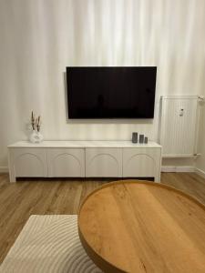a living room with a flat screen tv on a white cabinet at Exkluzívny apartmán v centre s parkovaním zadarmo ZV2 in Zvolen