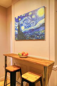 einen Tisch mit einer Schale Obst und einem Gemälde in der Unterkunft Suite Anna In Paris Republique in Paris