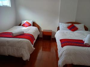 due letti uno accanto all'altro in una stanza di Hotel TIKA AYNA Cerca a la plaza de Armas CUSCO a Cuzco