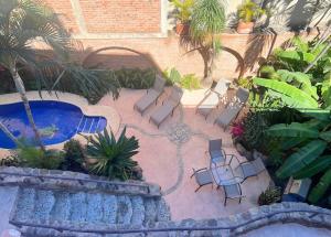 a patio with a pool and chairs and a table at Concha - Casa MoJo's cozy 1BR, garden, pool in Sayulita
