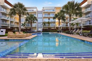 a swimming pool with chairs and palm trees in front of a building at 504 New, Fantastic Rooftop with Private Jacuzzi in La Laguna +18 photos