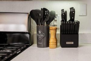 a container of knives on a counter next to a stove at Twin Pines Cabin in the Woods in Mountainaire +46 photos