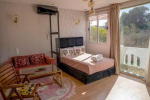 a bedroom with a bed and a couch and a window at Ba Sidi, Estudio in Tangier