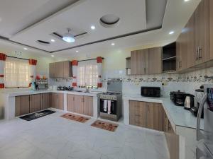a large kitchen with white marble counter tops and wooden cabinets at Green Gated Villa in Nakuru
