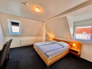 a bedroom with a bed and a window at Pension Dang in Norddeich
