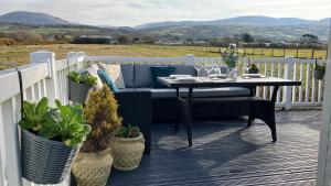 a porch with a couch and a table with plants at Barmouthbay209 in Barmouth +12 photos