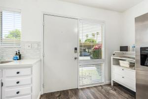 a white kitchen with a sink and a door at Camelback 446 at Fashion Square in Scottsdale