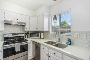 a white kitchen with a sink and a stove at Camelback 446 at Fashion Square in Scottsdale +21 photos