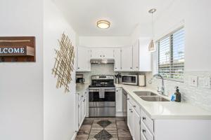 a white kitchen with white cabinets and a sink at Camelback 446 at Fashion Square in Scottsdale