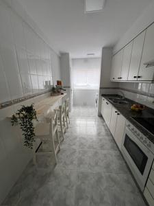 a kitchen with white cabinets and a table and chairs at mar in Moaña +9 photos