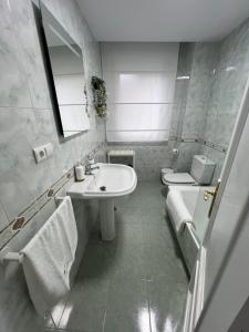 a white bathroom with a sink and a toilet at mar in Moaña