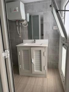 un baño con lavabo y espejo en Le cocon lumineux, en Sfax 7 fotos más