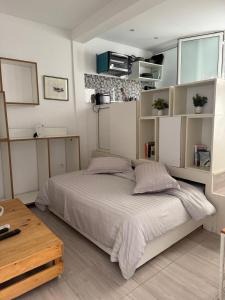 Un dormitorio con una cama grande y una mesa de madera. en Le cocon lumineux, en Sfax