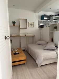 Un dormitorio con una cama y una mesa de madera. en Le cocon lumineux, en Sfax