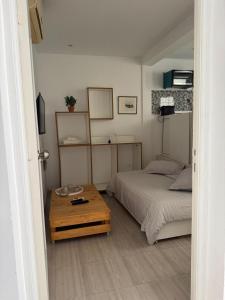 Un dormitorio con una cama y una mesa de madera. en Le cocon lumineux, en Sfax