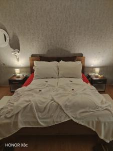 a large bed with white sheets and pillows on it at Sobe "Mira",Lipovac -Bajakovo in Lipovac