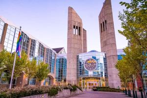 a building with two towers with a clock on it at 5BR-Luxury Retreat-Hot Tub-King Bed-Rogers Place-DT in Edmonton