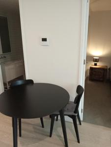 una mesa negra y sillas en una habitación en City views South Melbourne, en Melbourne