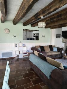 un soggiorno con un divano e un tavolo di Three Bedroom Breton Cottage a Collorec