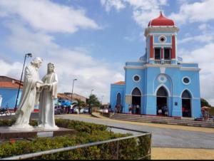 a blue building with a statue in front of it at Suíte perto do Centro e de Praias in São Luís