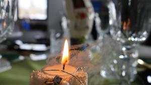 a candle is lit in a glass holder on a table at VILA RAISA in Neagra Şarului